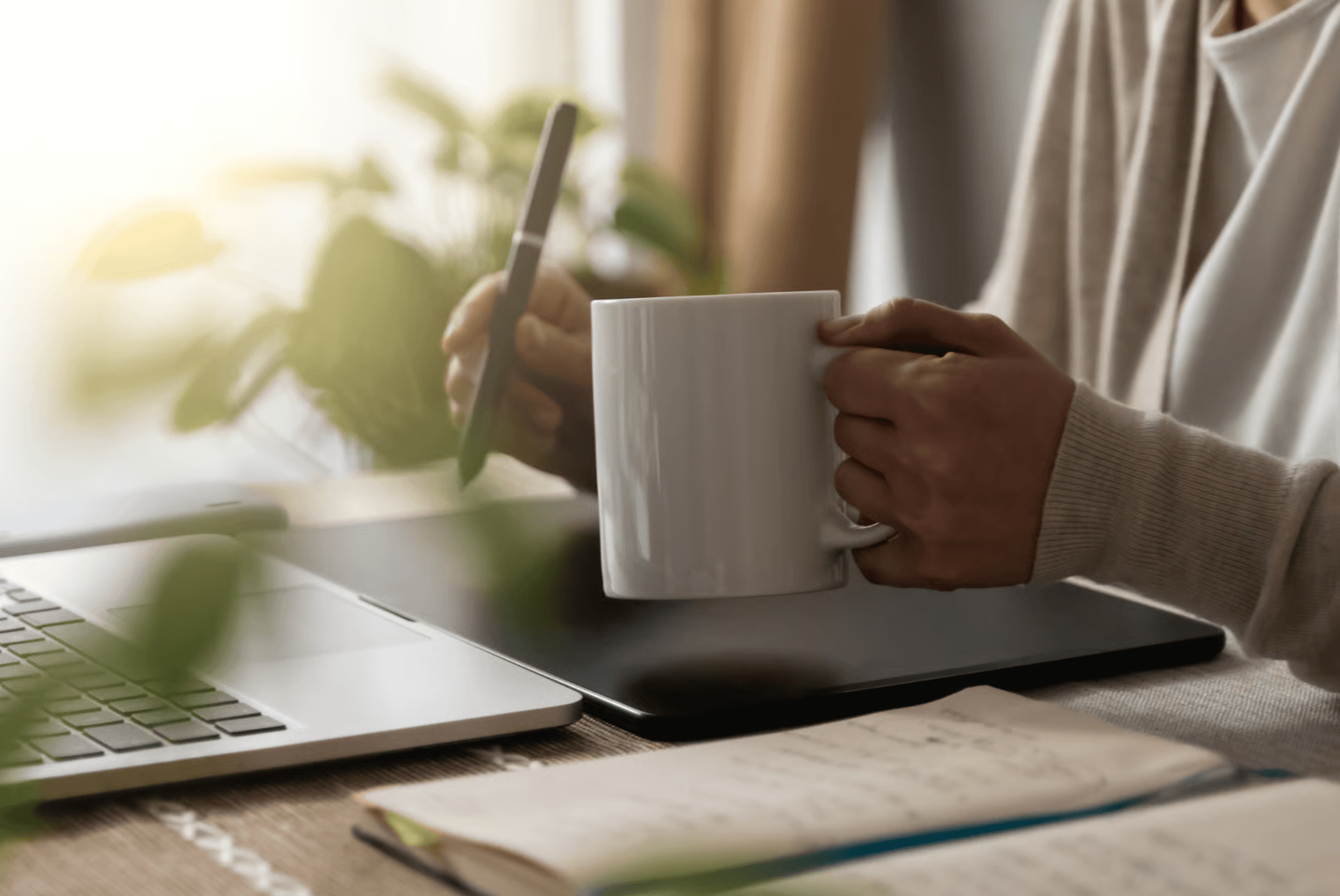 A person taking a calm moment with a coffee at their desk