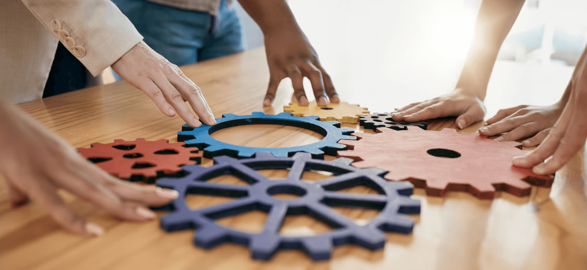 Colleagues assembling interlocking gears together, representing partnership